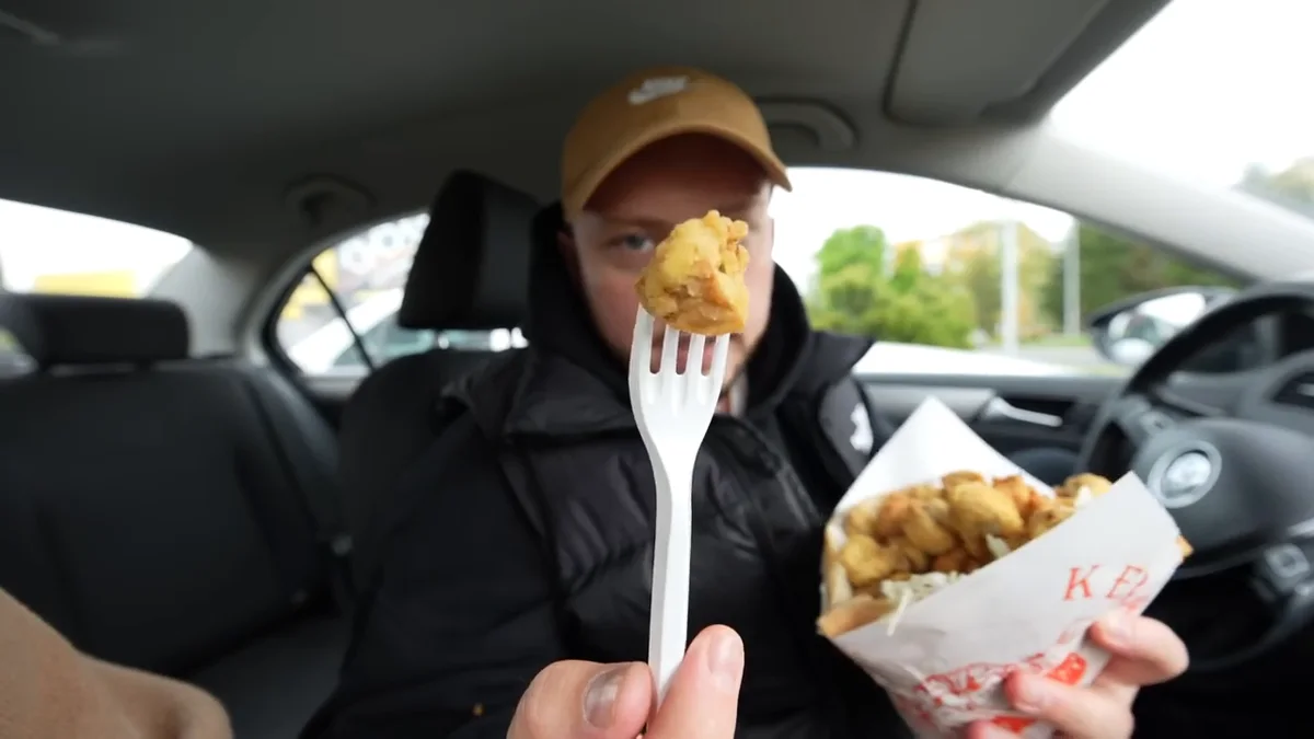 Kawałek pieczarki w panierce na plastikowym widelcu nad rożkiem z Big Buffalo