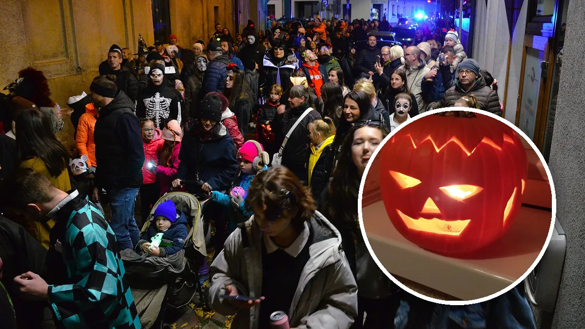 Tłum ludzi w halloweenowych przebraniach na wieczornej paradzie, w kółku wydrążona dynia ze świeczką