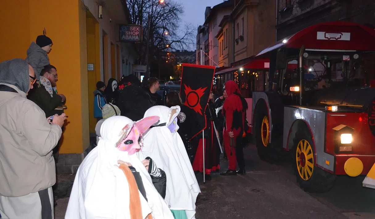 Ludzie przebrani za duchy na halloweenowej paradzie w mieście wieczorem