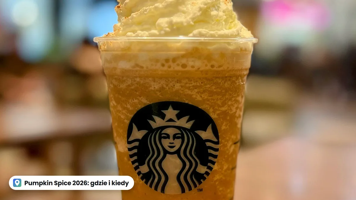 Pumpkin Spice Frappuccino z bitą śmietaną w plastikowym kubku Starbucks na stoliku w kawiarni