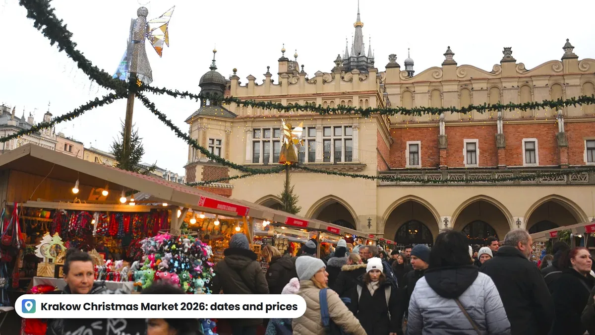 Christmas stalls and crowds on the Main Square in Krakow, with the Cloth Hall decorated with garlands in the background