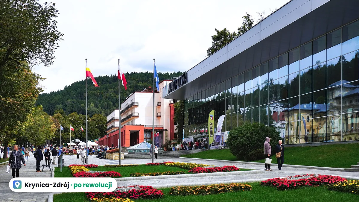 Deptak w Krynicy-Zdroju przy przeszklonej Pijalni Głównej, spacerowicze i rabaty kwiatowe