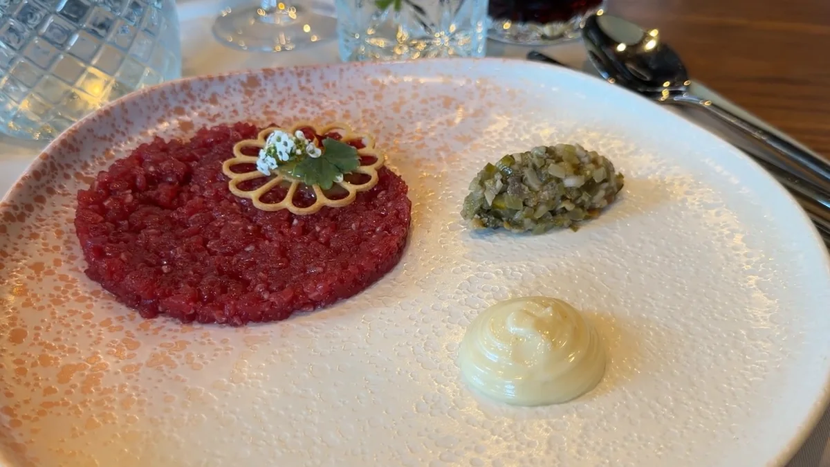 Tatar z polędwicy wołowej Black Angus z wędzonym majonezem i domowymi marynatami na talerzu w restauracji Natura