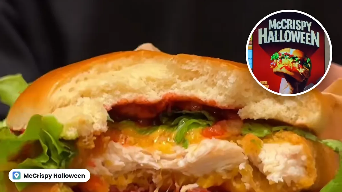 Przekrojony burger McCrispy Halloween z kurczakiem w panierce, serem i sałatą, w kółku plakat burgera z ekranu w restauracji