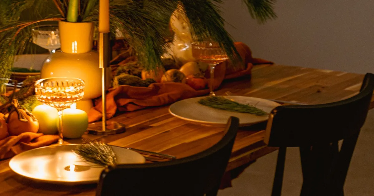 Nakryty stół w restauracji przy świecach, kieliszki i kwiaty