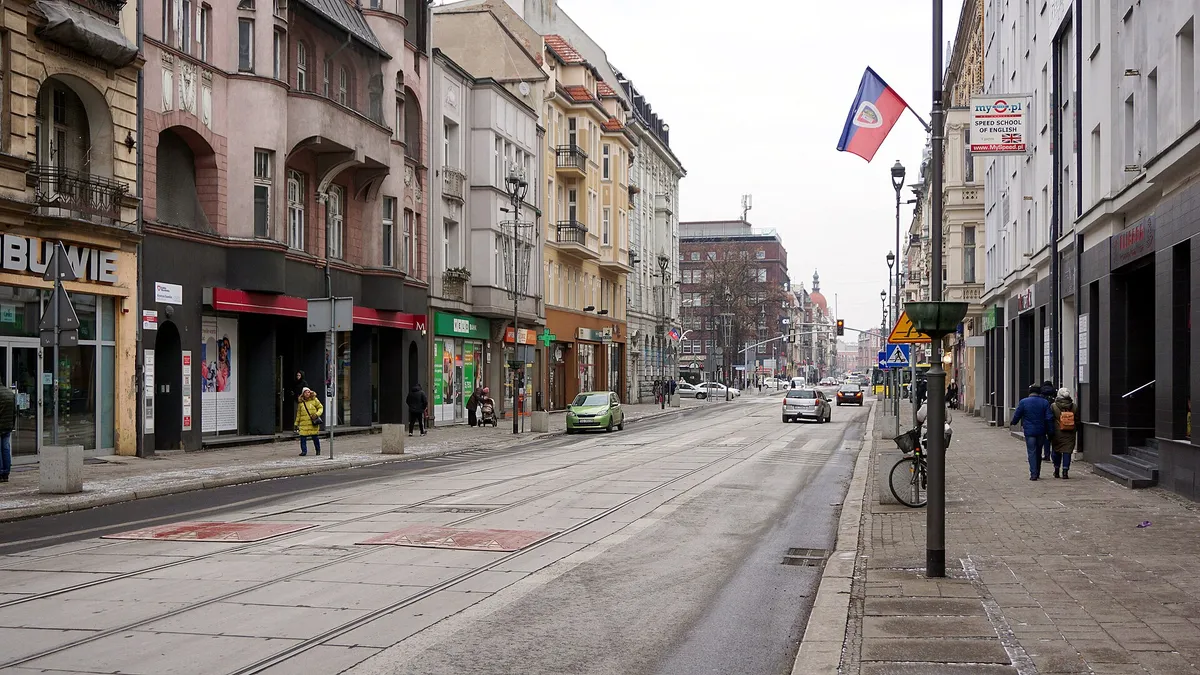 Ulica Zwycięstwa w Gliwicach zimą, kamienice, tory tramwajowe i przechodnie