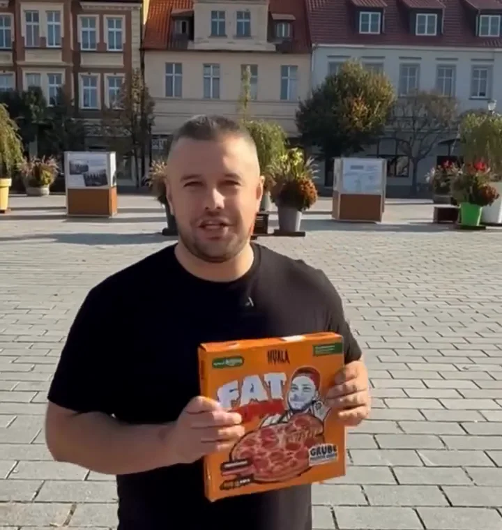 Właściciel Szamki z pudełkiem pizzy Fat Peppa na rynku we Wrześni