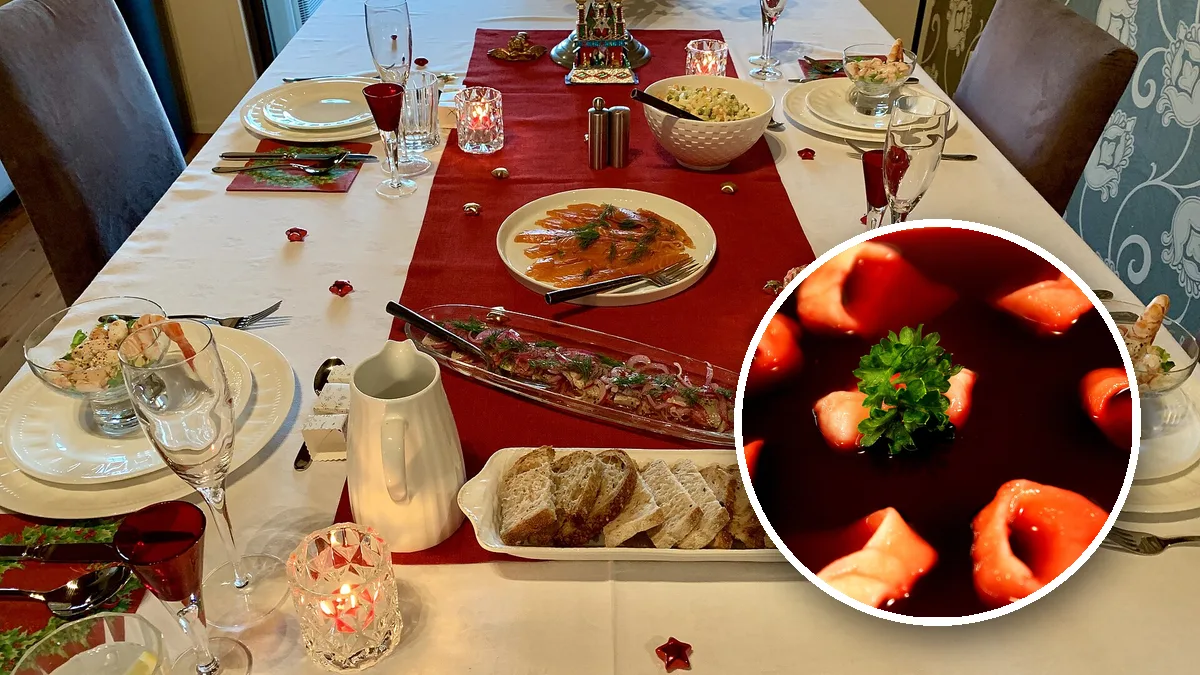 Nakryty wigilijny stół z rybami, sałatką i pieczywem, w kółku barszcz z uszkami