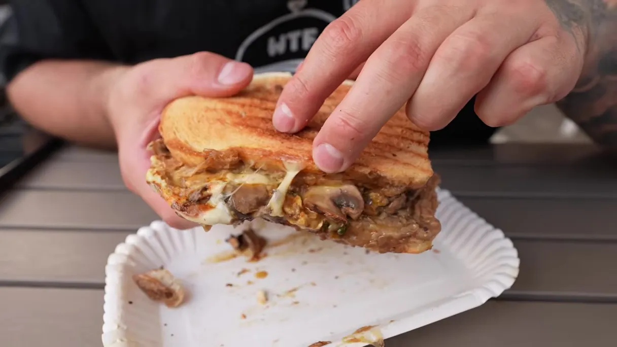 Rozpadający się tost z serem i pieczarkami z Baru Witek na papierowej tacce